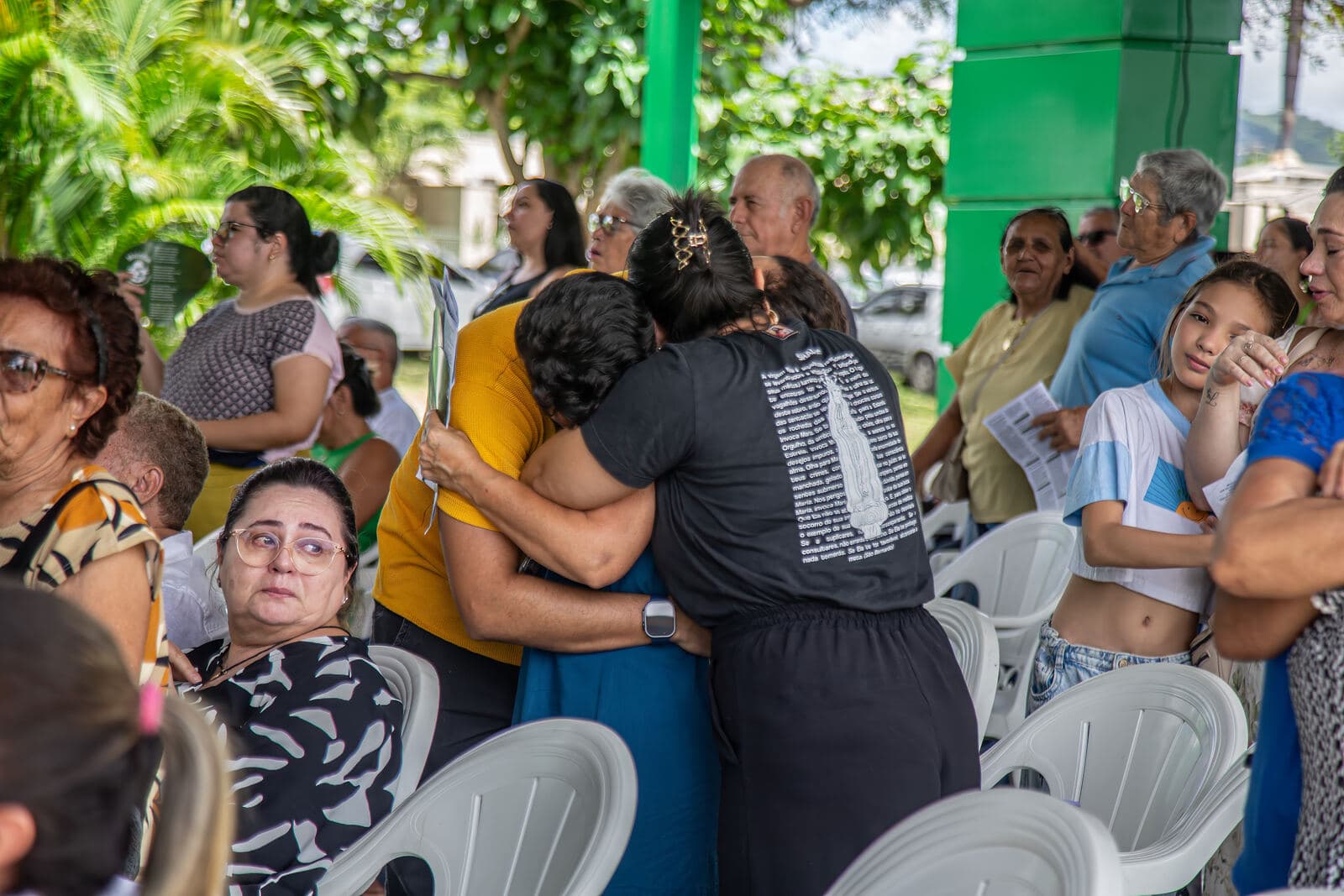 Abraço emocionado entre mães durante a celebração