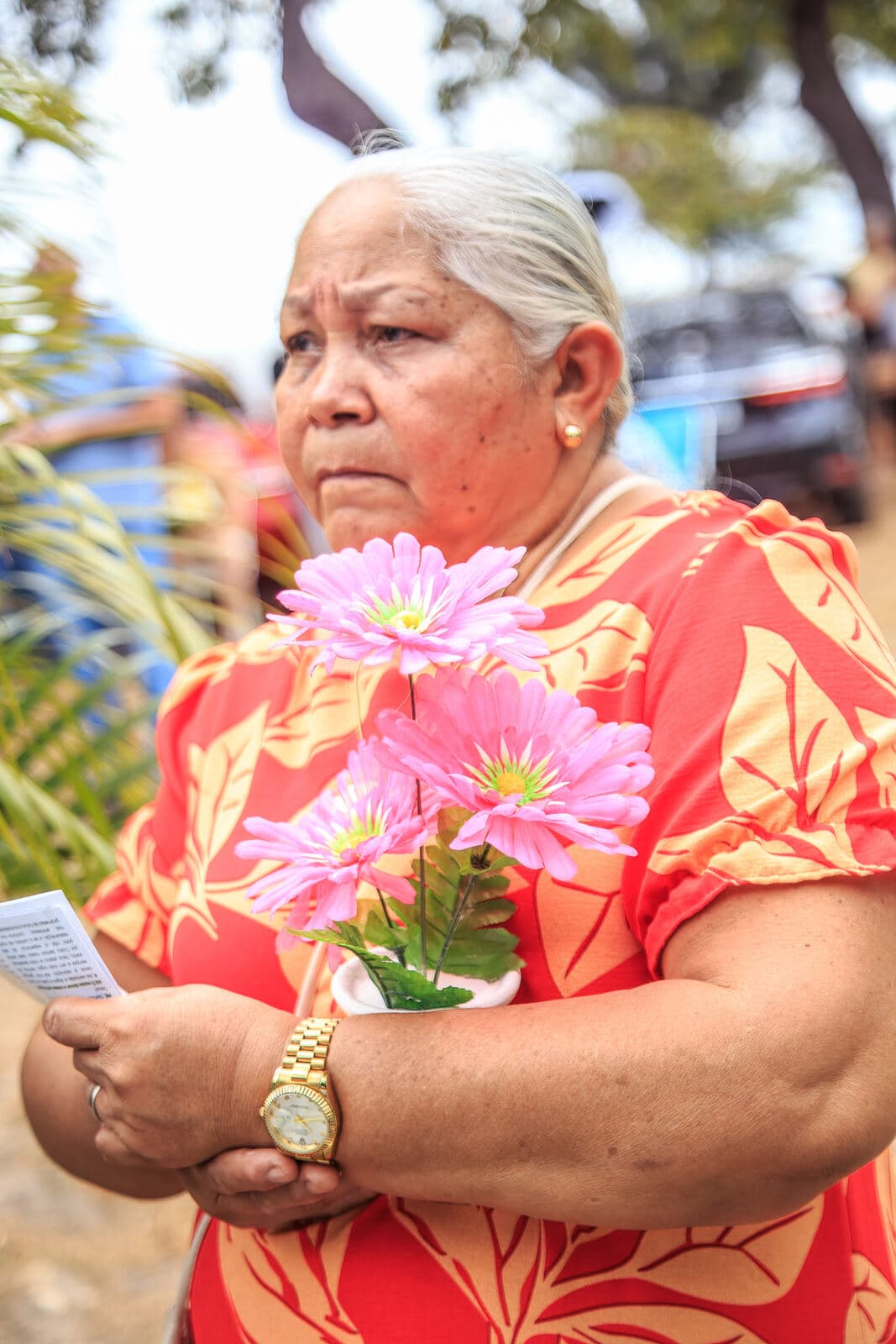 Senhora com flores nas mãos no Dia de Finados
