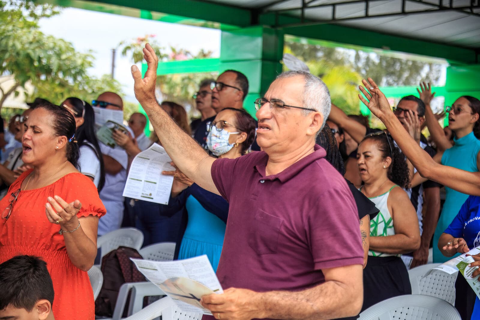 Famílias em oração com as mãos erguidas no Finados